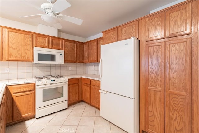 kitchen with light tile patterned flooring, white appliances, ceiling fan, and decorative backsplash