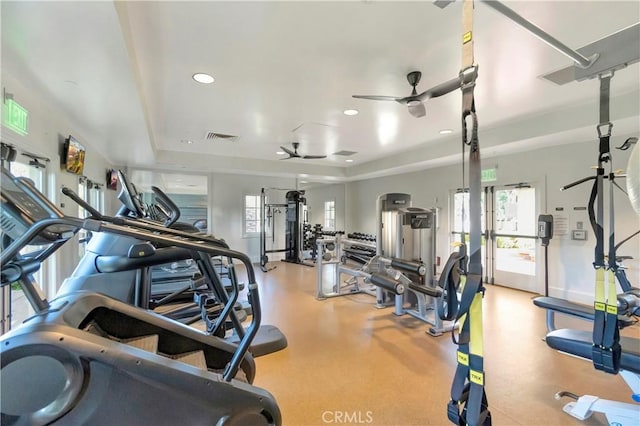 exercise room with a ceiling fan, a healthy amount of sunlight, visible vents, and baseboards