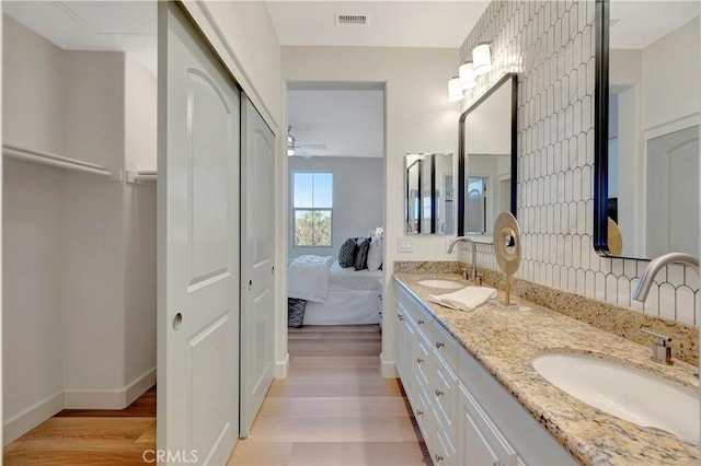 full bathroom featuring wood finished floors, visible vents, a sink, and ensuite bathroom