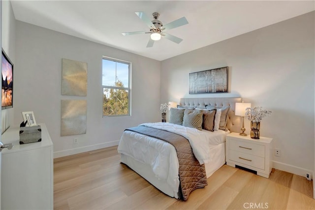 bedroom with ceiling fan, light wood-style flooring, and baseboards