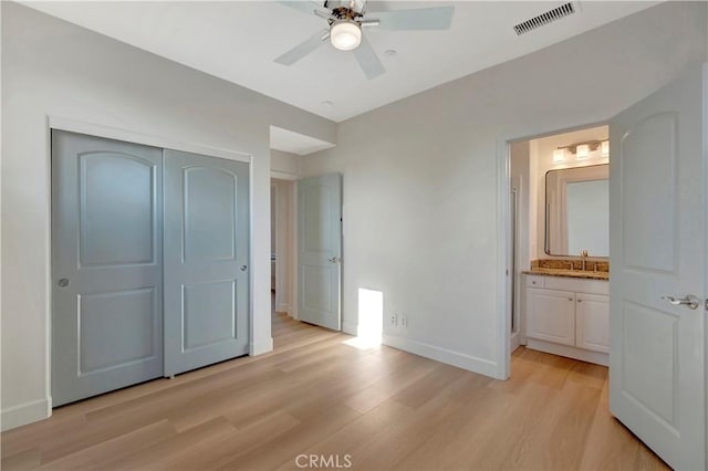 unfurnished bedroom featuring a closet, visible vents, light wood-style flooring, connected bathroom, and baseboards