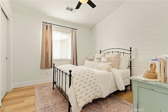 bedroom featuring vaulted ceiling, a closet, ceiling fan, and light hardwood / wood-style flooring