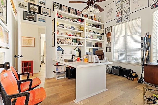 home office with light hardwood / wood-style floors and ceiling fan