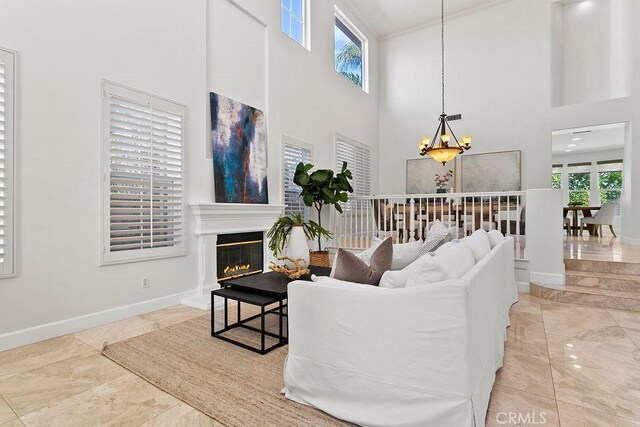 1019 N Sonora Cir, Orange, CA 92869 - living area featuring a chandelier, a high ceiling, baseboards, ornamental molding, and a glass covered fireplace