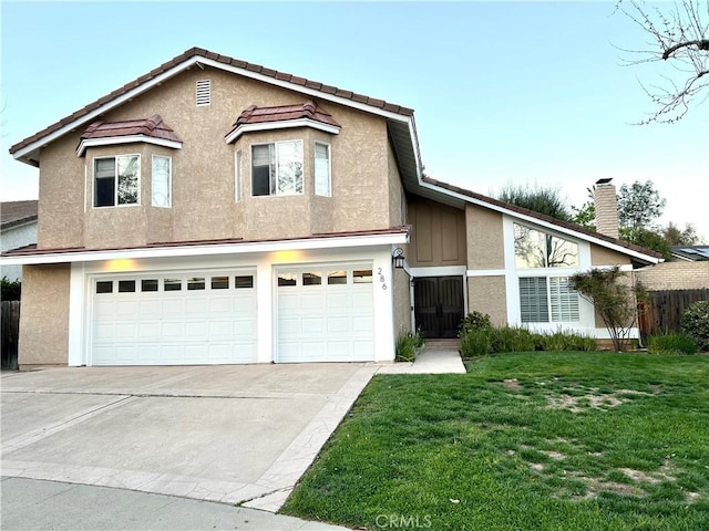 traditional-style home featuring a garage, stucco siding, concrete driveway, and a front yard