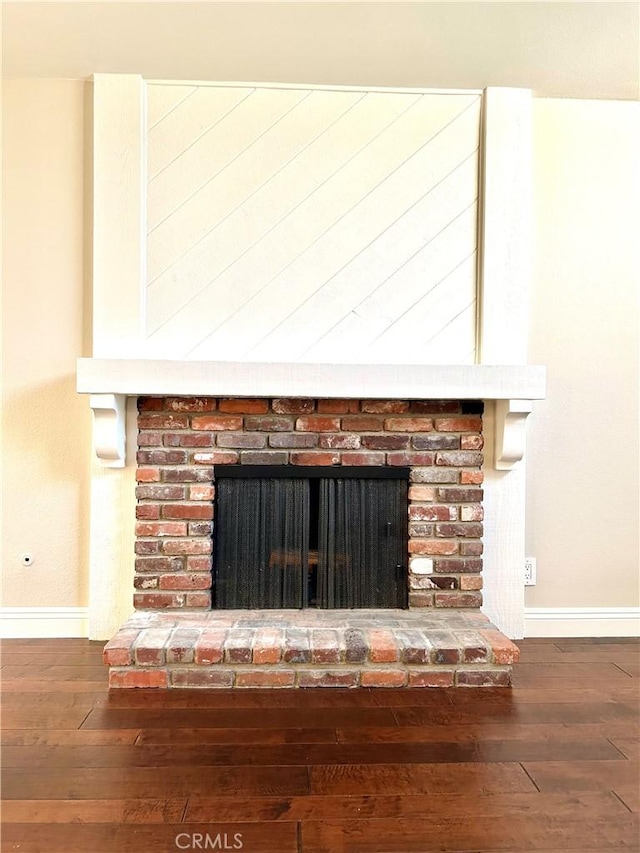 details with a brick fireplace, baseboards, and wood finished floors