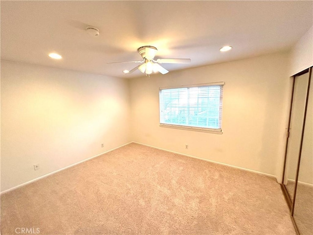 unfurnished bedroom with recessed lighting, a closet, a ceiling fan, and carpet flooring