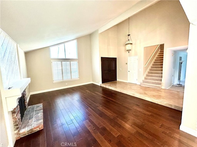 unfurnished living room featuring stairway, baseboards, a brick fireplace, and hardwood / wood-style floors