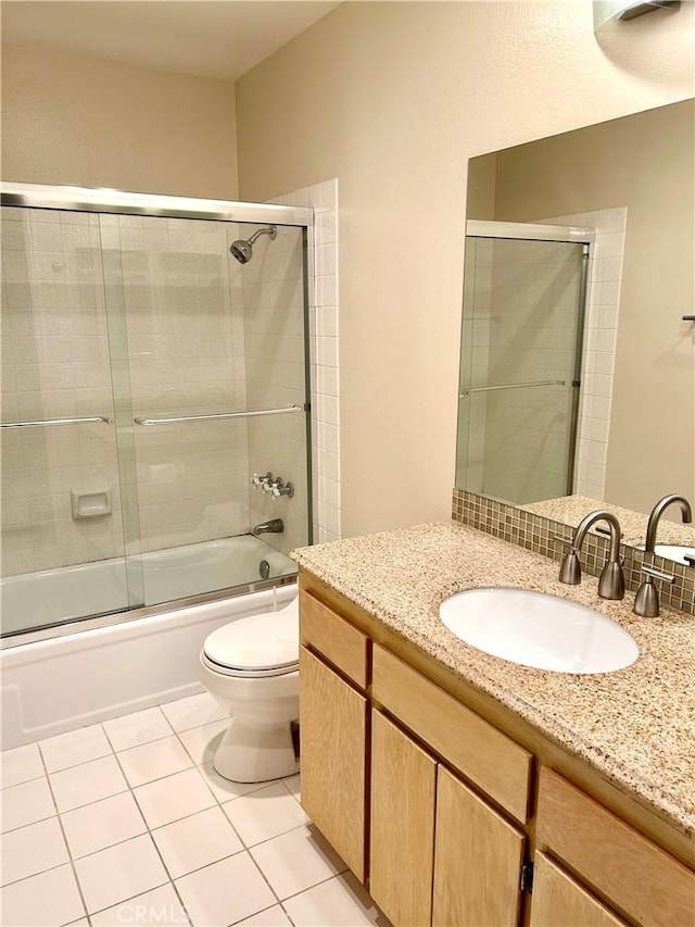 full bath featuring tile patterned flooring, vanity, toilet, and enclosed tub / shower combo