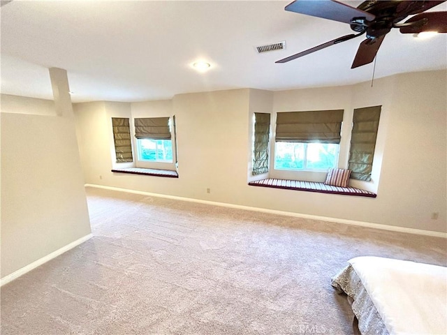 unfurnished bedroom with carpet, multiple windows, visible vents, and baseboards