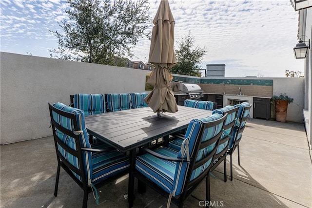 view of patio / terrace featuring exterior kitchen and a grill