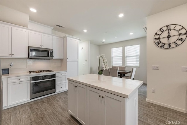 kitchen featuring a kitchen island, appliances with stainless steel finishes, and white cabinets