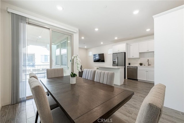 dining space featuring sink and light hardwood / wood-style flooring