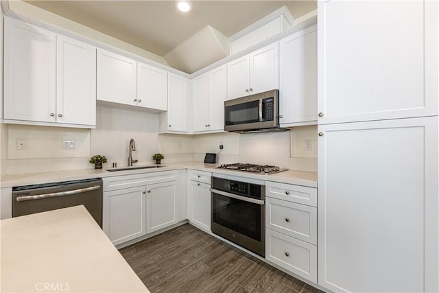 kitchen with white cabinetry, stainless steel appliances, dark hardwood / wood-style floors, and sink