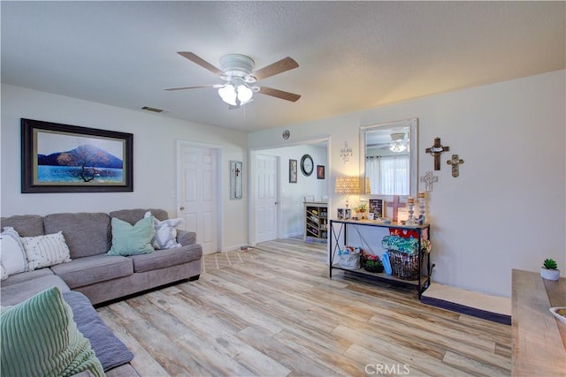 living room with ceiling fan and light wood-type flooring