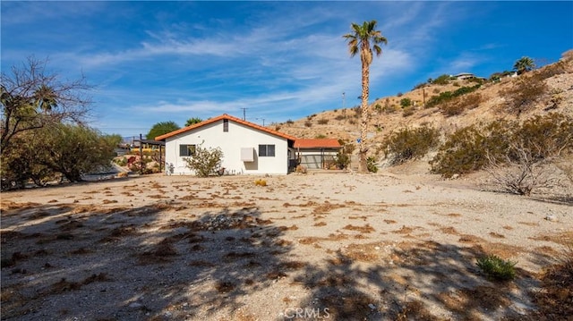 view of side of property featuring a mountain view and stucco siding