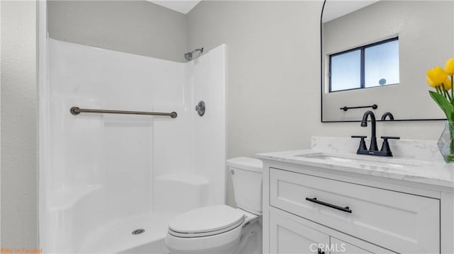 bathroom with walk in shower, vanity, and toilet