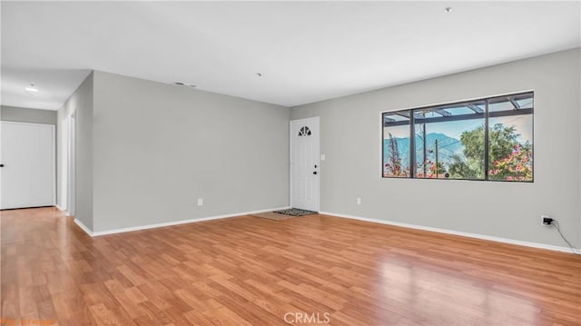 unfurnished room featuring light wood-type flooring and baseboards