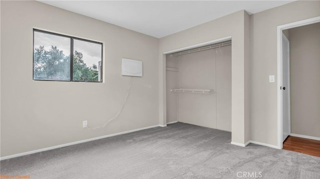 unfurnished bedroom featuring light carpet, a closet, and baseboards