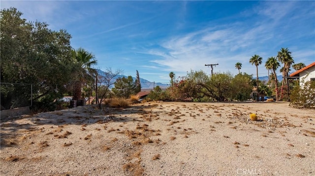 view of yard featuring fence and a mountain view