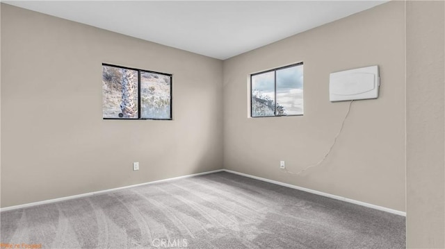 carpeted empty room featuring baseboards