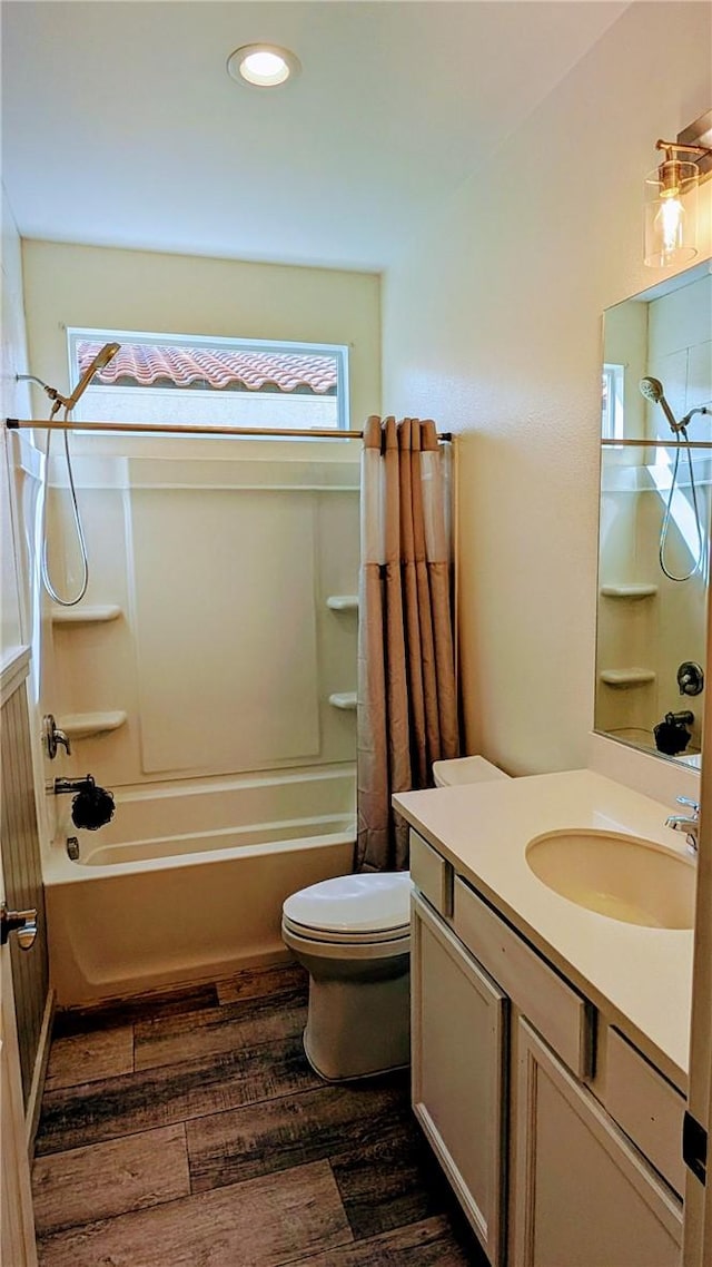 full bathroom with hardwood / wood-style flooring, vanity, toilet, and shower / bath combo with shower curtain