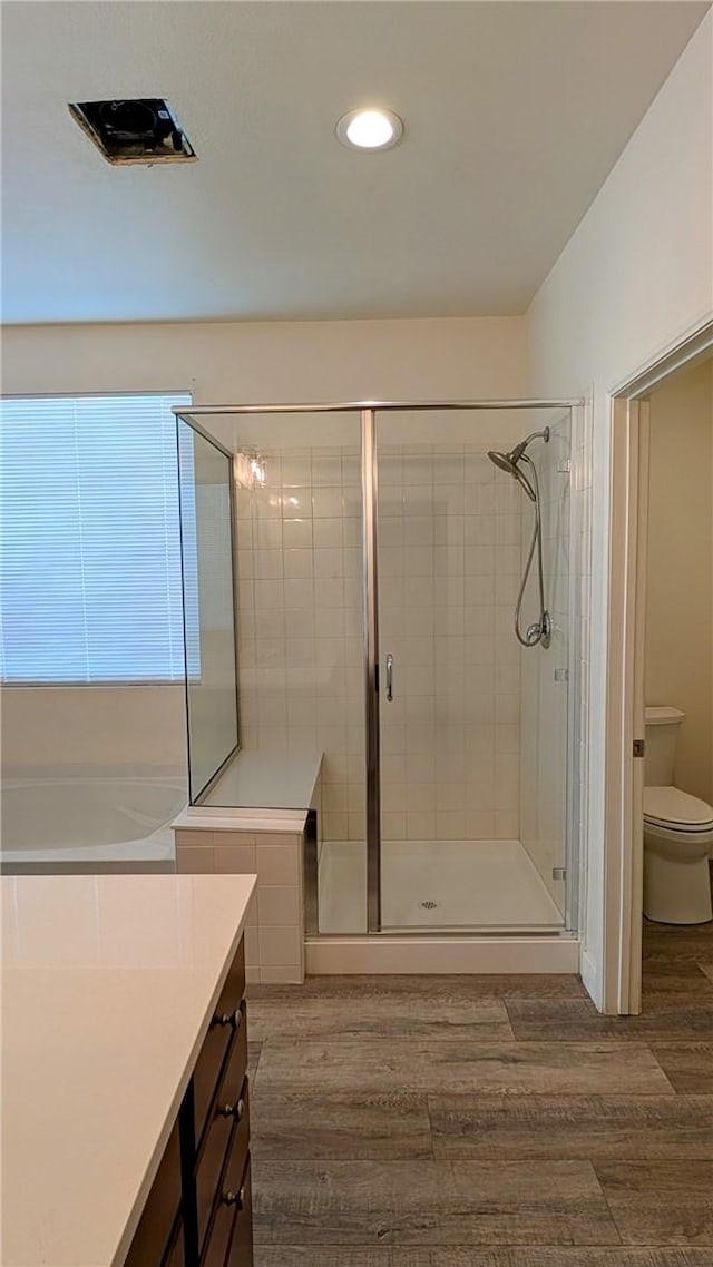 full bathroom with vanity, toilet, independent shower and bath, and hardwood / wood-style floors