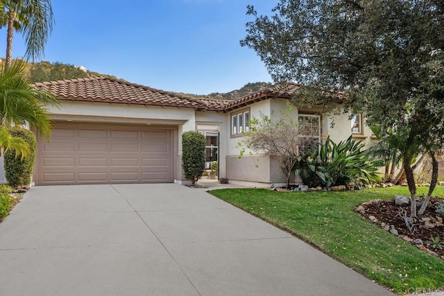 mediterranean / spanish-style house with a garage and a front yard