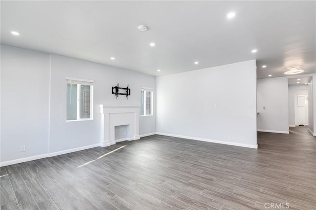 unfurnished living room featuring baseboards, wood finished floors, and recessed lighting