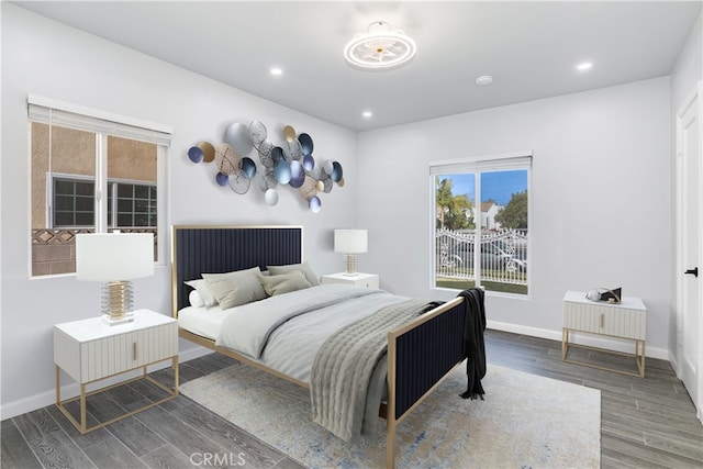 bedroom featuring baseboards, multiple windows, wood finished floors, and recessed lighting