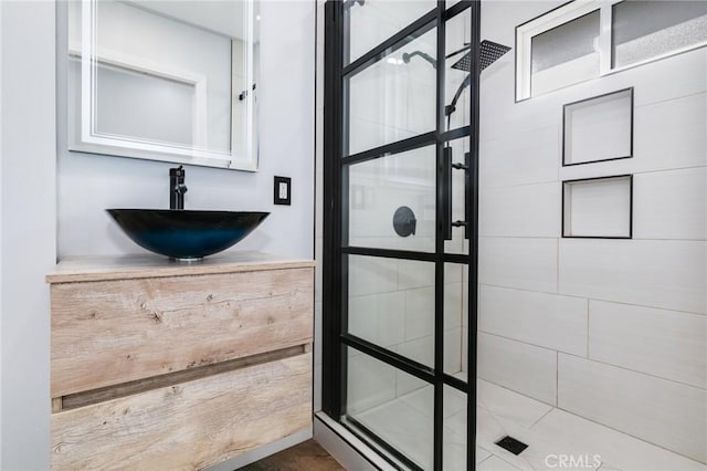 full bathroom with vanity and a tile shower
