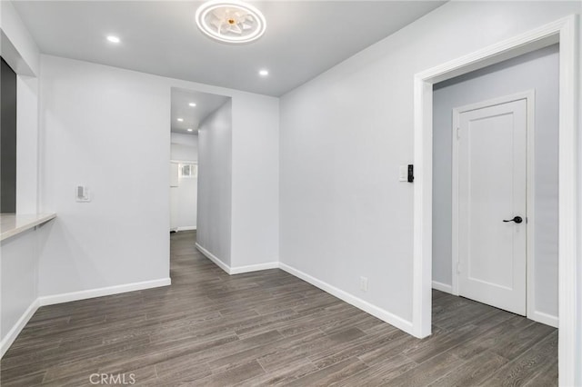 spare room with baseboards, wood finished floors, and recessed lighting