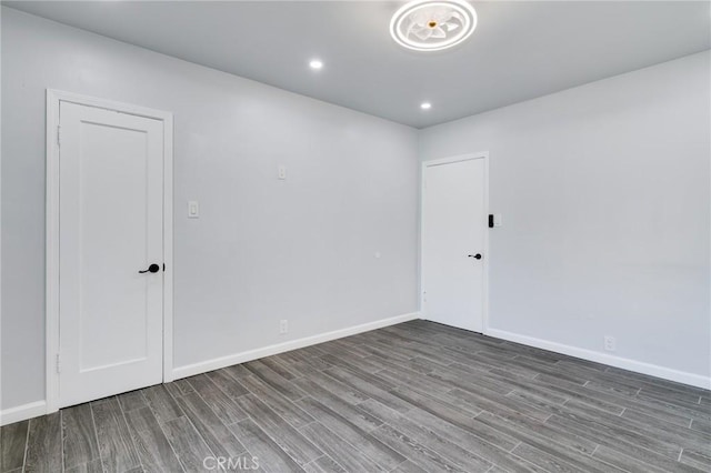 unfurnished room with recessed lighting, wood finished floors, and baseboards