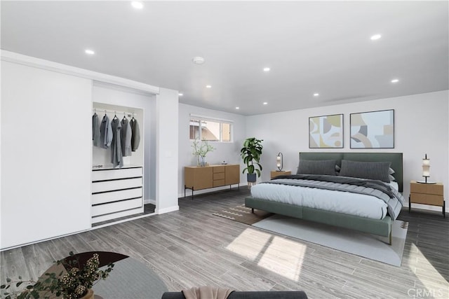 bedroom with baseboards, wood finished floors, and recessed lighting