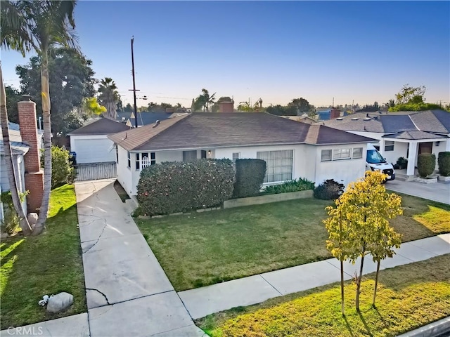 ranch-style home with an outdoor structure, a residential view, a front lawn, and stucco siding