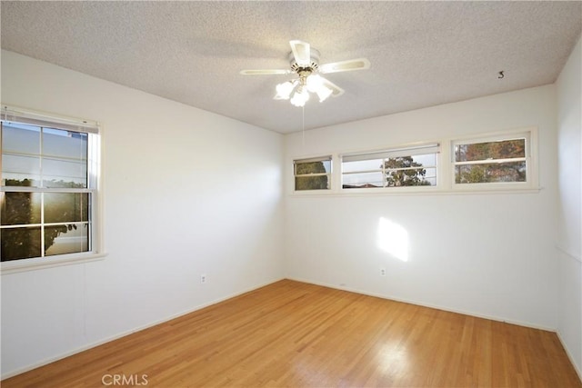 spare room with a textured ceiling, ceiling fan, and wood finished floors