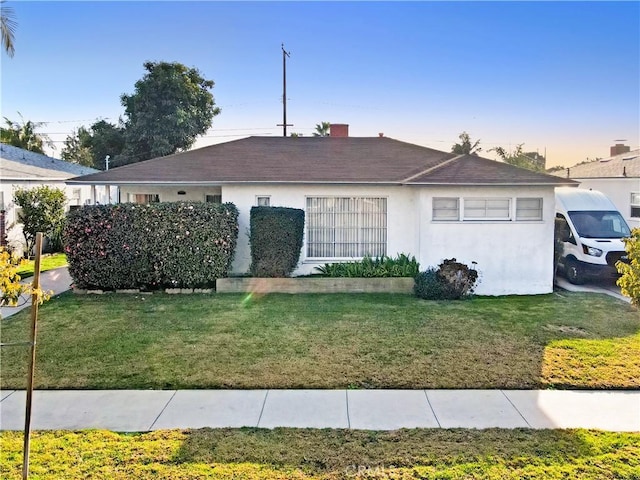 single story home with a front lawn and stucco siding