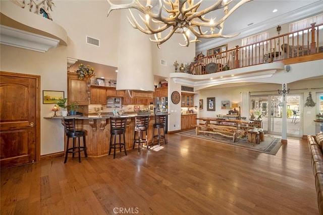 41700 Jojoba Hills Cir, Aguanga, CA 92536 - dining space with hardwood / wood-style flooring, ornamental molding, a chandelier, and a high ceiling