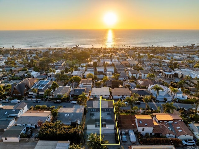 aerial view at dusk featuring a water view