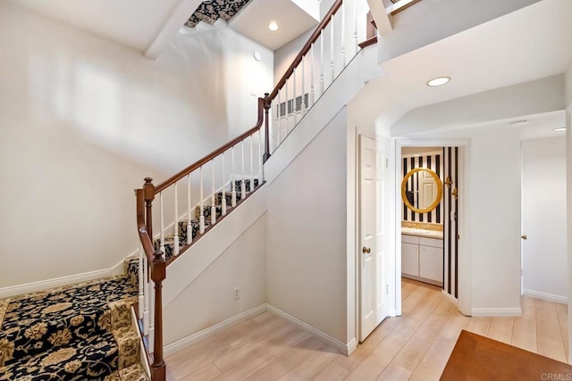 stairway featuring hardwood / wood-style floors and a high ceiling