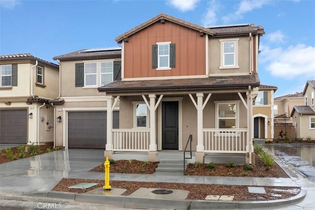 view of front of home featuring an attached garage, board and batten siding, covered porch, stucco siding, and driveway