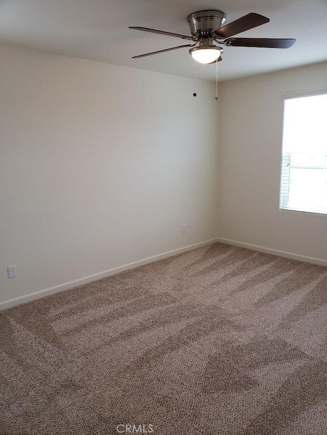 spare room featuring carpet and ceiling fan