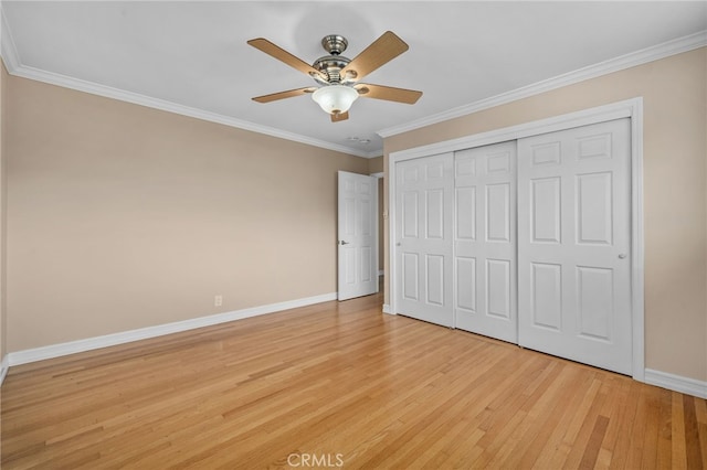 unfurnished bedroom with crown molding, a closet, ceiling fan, and light hardwood / wood-style flooring