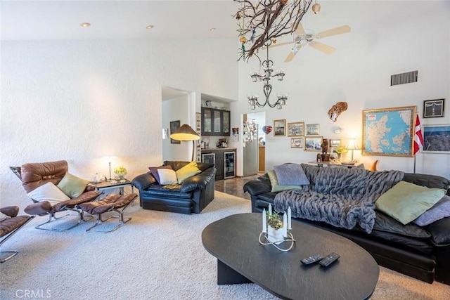 living room with a high ceiling, carpet flooring, wine cooler, and ceiling fan