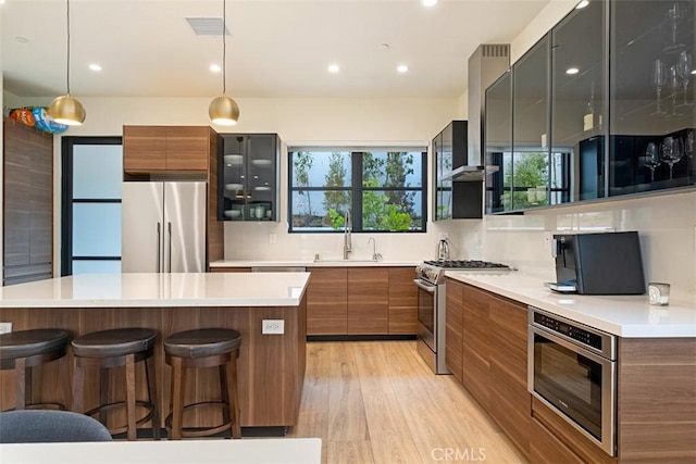 kitchen featuring sink, a wealth of natural light, pendant lighting, stainless steel appliances, and backsplash