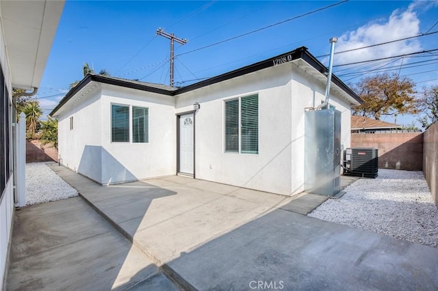 rear view of property featuring a patio area and central air condition unit