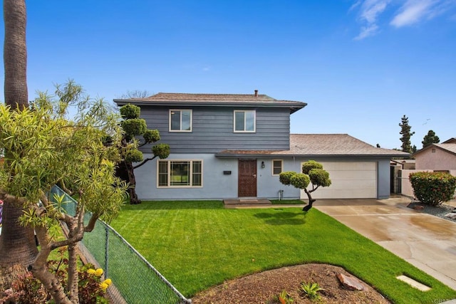 traditional-style home with a garage, driveway, a front yard, and fence