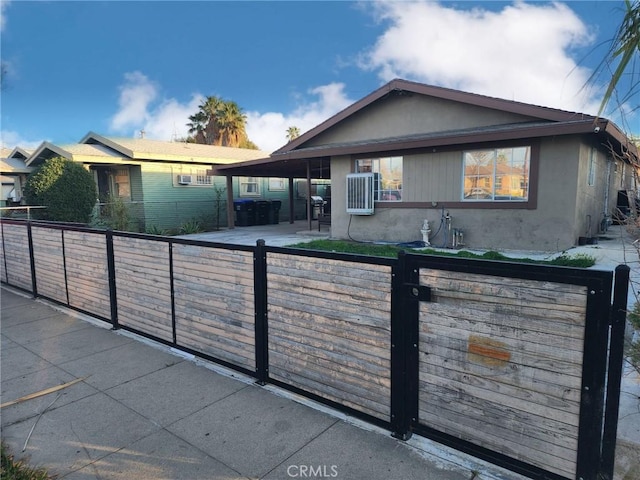 view of front of home featuring a fenced front yard, a gate, and stucco siding