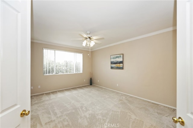 carpeted spare room featuring ornamental molding and ceiling fan