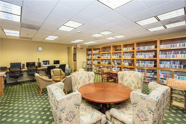 dining area with a paneled ceiling and carpet